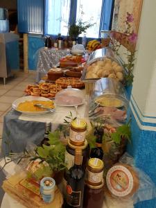 a table filled with food and bottles of wine at Hotel Baia Cea in Bari Sardo