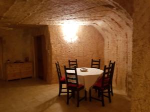 une salle à manger avec une table et des chaises blanches dans l'établissement Underground Gem, à Coober Pedy