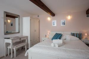 a bedroom with a white bed and a desk and a mirror at Apartment Stulli 1 in Dubrovnik