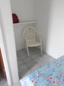 a bedroom with a chair and a table at Hotel Pousada Guaratuba in Guaratuba