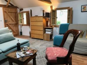 Lavender Lodge في Rupkite: غرفة معيشة مع أريكة وطاولة وكرسي