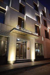 ハタイにあるWaxwing Hotelの揺れるホテルの看板のある建物