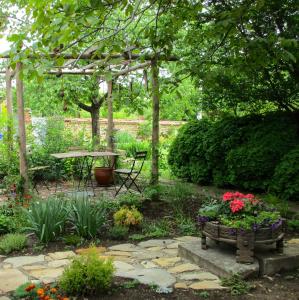 um jardim com uma mesa e um banco e flores em Lavender Lodge em Rupkite