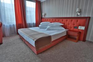 a bedroom with a large bed with a red headboard at Marina Residence Boutique Hotel in Varna City