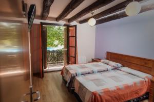 Un dormitorio con dos camas y una gran ventana. en Camping & Bungalows Ligüerre de Cinca, en Ligüerre de Cinca