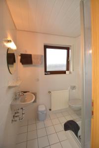 a white bathroom with a sink and a toilet at Weingut***Pension Günther Scholtes in Leiwen