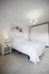 コスタ・カルマにあるCardon Big Calm 10の白いベッドルーム(大型ベッド1台、テーブル付)