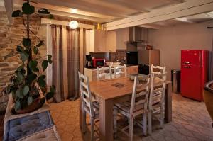 馬朗的住宿－La Ferme de Fossillon，厨房配有桌椅和红色冰箱。