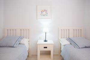 two twin beds in a room with a nightstand between them at Cardon Big Calm 12 in Costa Calma