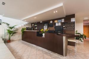 a restaurant with a counter and a bar in a building at Hotel Romina in Rimini