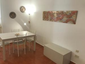 ローマにあるAppartamento Vicino al Vaticanoのダイニングルーム(テーブル、椅子、絵画付)