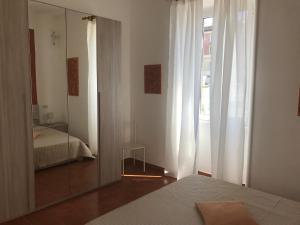 ローマにあるAppartamento Vicino al Vaticanoの鏡とベッドと鏡付きのベッドルーム1室