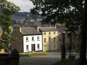 a white house with a green door in a city at Castle View in Lancaster