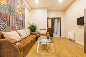 uma sala de estar com um sofá e uma mesa de vidro em Sweet Home Apartment VIP 1 em Tbilisi