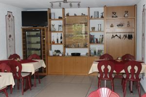 une salle à manger avec des tables, des chaises et une télévision dans l'établissement Weingut***Pension Günther Scholtes, à Leiwen