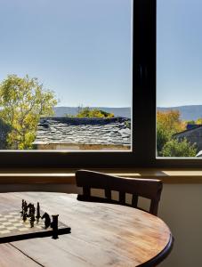 ein Zimmer mit einem Schachbrett und einem Tisch mit einem Fenster in der Unterkunft Casa la Devesa de Sanabria in Remesal