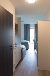 a room with a bed and a room with a door at FirstSleep Boardinghouse Griesfeldstrasse München in Munich