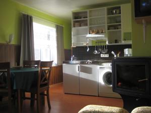 une cuisine avec un lave-linge et une table avec des chaises dans l'établissement Piiri Holiday House, à Otepää