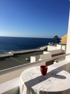 カジャオ・サルバヘにあるEl Anclaの海を望むバルコニーのテーブルに置かれた赤い鉢