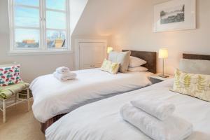 two beds in a room with two windows at The Square in Kelso