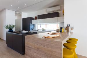 a kitchen with a counter with yellow stools at Villa Soleil in Vela Luka