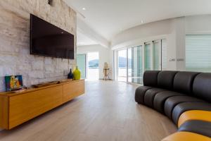 a living room with a couch and a flat screen tv at Villa Soleil in Vela Luka