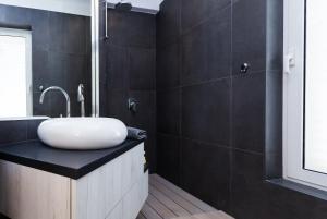 a bathroom with a white sink on a black counter at Villa Soleil in Vela Luka