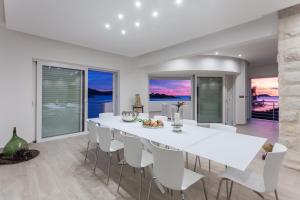 a white dining room with a white table and chairs at Villa Soleil in Vela Luka