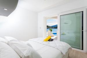a bedroom with a white bed with a yellow object on it at Villa Soleil in Vela Luka
