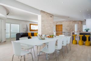 a kitchen and dining room with a white table and chairs at Villa Soleil in Vela Luka