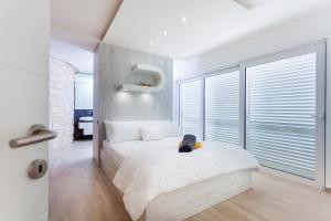 a bedroom with a white bed with a large window at Villa Soleil in Vela Luka