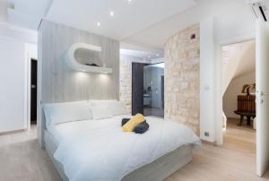a bedroom with a white bed with a yellow stuffed animal on it at Villa Soleil in Vela Luka