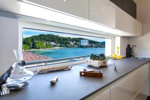 a kitchen counter with a large window with a view at Villa Soleil in Vela Luka
