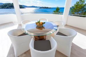a glass table on a balcony with a bowl of fruit at Villa Soleil in Vela Luka