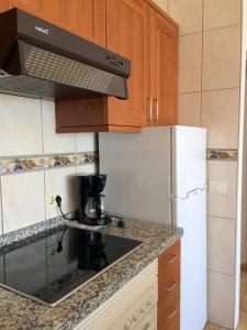 カジャオ・サルバヘにあるEl Anclaのキッチン(白い冷蔵庫、コンロ付)