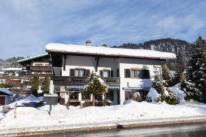 a house with snow on the ground in front of it at DEVA Hotel Kaiserblick in Reit im Winkl +37 photos