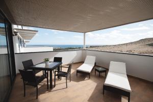 un balcone con tavolo e sedie e l'oceano di Cardon Big Calm 19 a Costa Calma