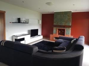 Una sala de estar con un sofá y una chimenea. en Deluxe Home Praia do Populo, en Cabouco