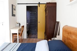 1 dormitorio con cama, escritorio y puerta en B&B PeperZzz, en Bergen
