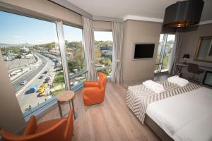 イスタンブールにあるマンソル オールド シティ ボスポラスのベッドと大きな窓が備わるホテルルームです。