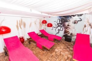 a room with pink chairs and a wall with a picture at DEVA Hotel Kaiserblick in Reit im Winkl