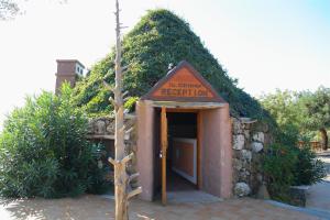 a building with a sign that reads the entrance to a repair center at Hotel Turismo Rurale Villa Maria Caterina in Cala Gonone