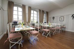 uma sala de jantar com mesas, cadeiras e janelas em Der Linslerhof - Hotel, Restaurant, Events & Natur em Überherrn