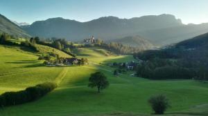 ein grünes Feld mit einem Haus darüber in der Unterkunft Ferienhof Unterführholzergut in Klaus