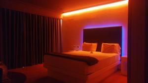 a bedroom with a bed with a blue light at Motel Trebol in Tui
