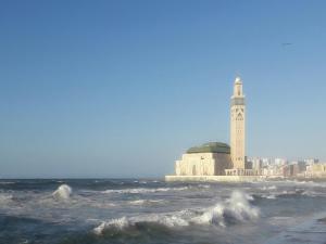 un bâtiment avec une tour d'horloge sur la plage dans l'établissement Horizon Home, à Casablanca
