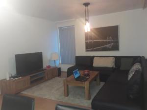 uma sala de estar com um sofá e uma televisão em Comfortable Bedrooms - King size beds em Hafnarfjördur