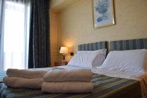 a hotel room with a bed with towels on it at Hotel President Pomezia in Pomezia