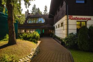 a building with a sign on the side of it at Nature Clinic Park Hotel in Józefów