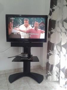 a flat screen tv sitting on a stand in a room at Villagiannis in Nea Fokea